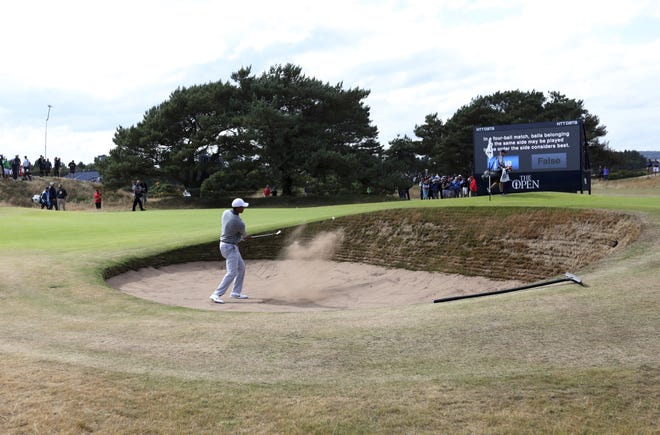 Tiger Woods plays out of a bunker on the 13th hole Wednesday during a practice round ahead of the British Open Golf Championship in Carnoustie, Scotland. [The Associated Press / Jon Super]