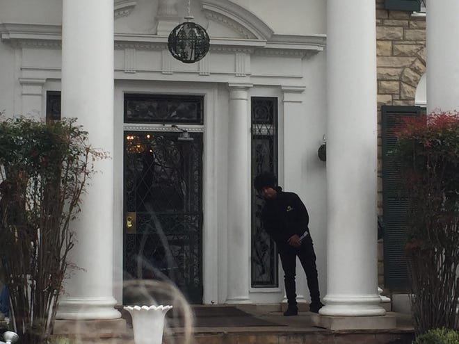 A tour guide at Graceland’s front door awaits the next busload of visitors. [Photo by Rick Holmes]