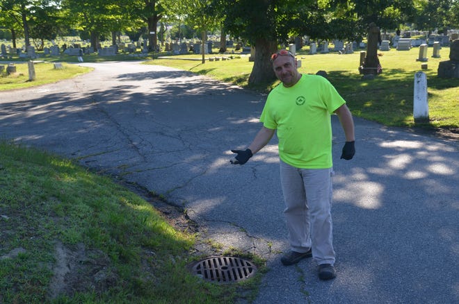 John Moniz of Bristol County Mosquito Control Project treats a catch basin. [Photo by Michael Coughlin]