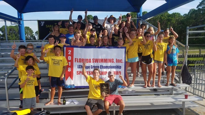 The Sarasota YMCA Sharks 14-Under swim team celebrates after winning the Florida Age Group Long Course Championships at the Selby Aquatic Center in Sarasota over the weekend. [COURTESY PHOTO]