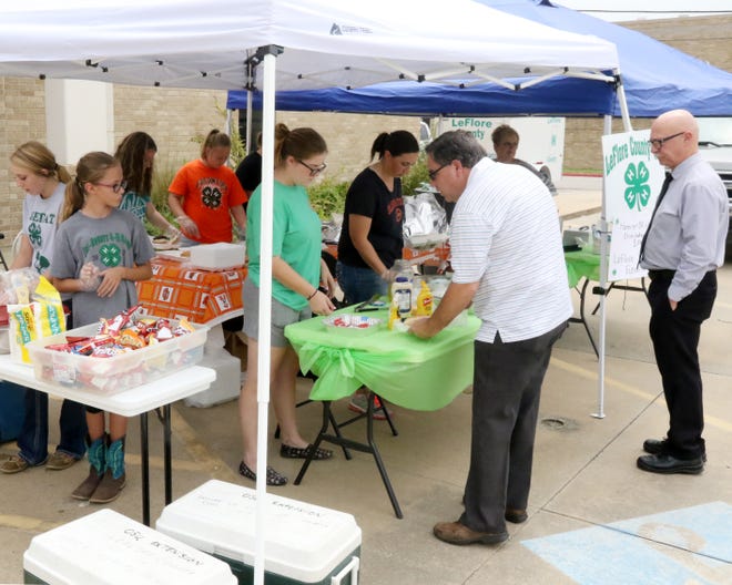 Supporters of the LeFlore County 4H Youth line up for to buy a hamburger plate with chips, cookie and drink Wednesday, July 18, 2018, during the organization's hamburger fundraiser at the LeFlore County Courthouse parking lot on N. Church Street in Poteau. The funds raised by the 4H club go to helping support LeFlore County 4H youth with cost associated with educational activities, events and awards. [JAMIE MITCHELL/TIMES RECORD]