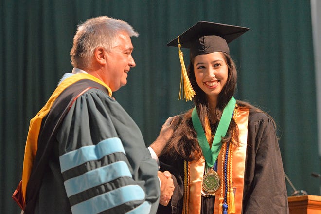 Graduate Renata Gomes Martins receives the President's Award from Dr. Stanley Sidor during Lake-Sumter State College's spring commencement on May 4 at the Everett A. Kelly Convocation Center in Leesburg. [Whitney Lehnecker / Daily Commercial]