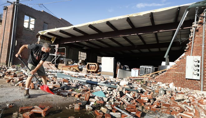 Roy Schweinebart, of Marshalltown, Iowa, shovels bricks from a tornado-damaged building near Main Street, Thursday, July 19, 2018, in Marshalltown, Iowa. Several buildings were damaged by a tornado in the main business district in town including the historic courthouse. (AP Photo/Charlie Neibergall)