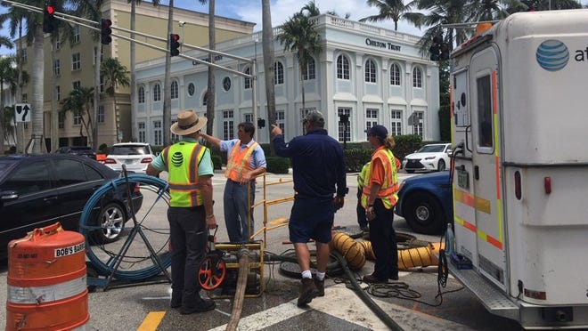 Crews work at the Royal Palm Way and Cocoanut Row intersection on July 12, 2018, in Palm Beach. During irrigation work in the median, AT&T lines were accidentally cut, knocking out service at Town Hall. William Kelly/Daily News