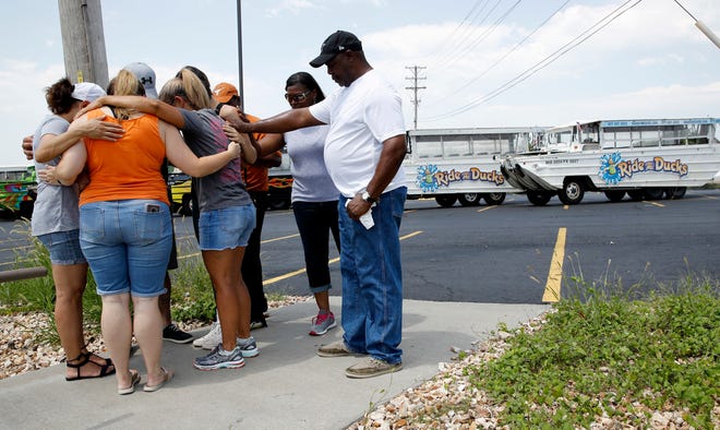 People pray outside Ride the Ducks, an amphibious tour operator involved in a boating accident on Table Rock Lake, Friday, July 20, 2018 in Branson, Mo. (AP Photo/Charlie Riedel)