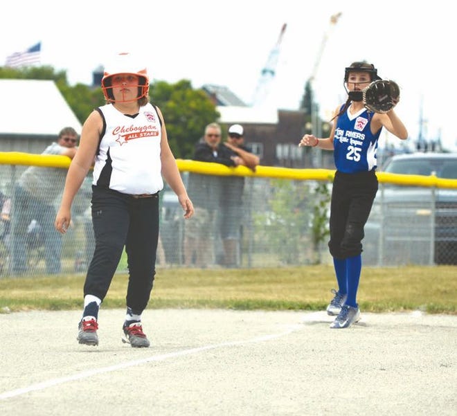 Cheboygan's Lily McKervey (left) takes a lead from third during a Minor Girls District 13 softball matchup against Tri Rivers in Cheboygan on Friday. Tri Rivers' Lucy Ditta looks to make a play at third base.