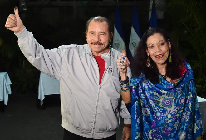 Nicaragua's President Daniel Ortega and his wife, vice presidential candidate Rosario Murillo show their marked thumbs after voting at a polling station near a his home in Managua, Nicaragua, Sunday, Nov. 6, 2016. Ortega appears headed for a a third consecutive term victory in the general election, but critics accused Ortega and his allies of manipulating the political system to guarantee he stays in power by dominating all branches of government. (Rodrigo Arangua/Pool via AP)