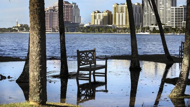 A bench off Lake Trail in Palm Beach sits surrounded after water washed in from the Intracoastal Waterway. A combination of the full moon, high tide, and sea level rise were blamed for the flooding. Daily News file photo by Lannis Waters