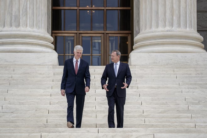 Associate Supreme Court Justice Neil Gorsuch, joined by Chief Justice John Roberts, stand outside the Supreme Court in Washington. [AP Photo/J. Scott Applewhite, File]
