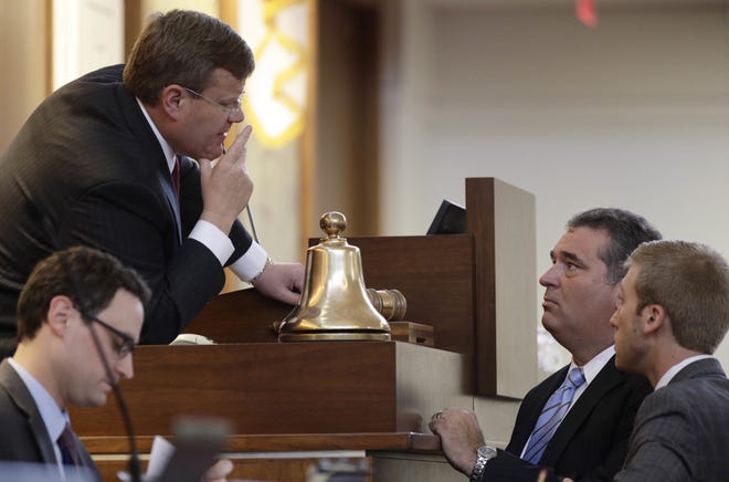 North Carolina House Speaker Tim Moore, R-Cleveland, upper left, speaks with Rep. David Lewis, R-Harnett and aid Marl Coggins, right, during a special session at the General Assembly in Raleigh on Tuesday. [AP Photo/Gerry Broome]