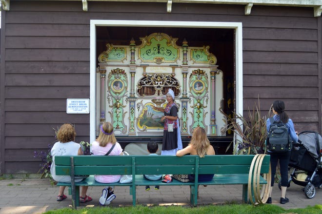 Visitors listen to the Amsterdam street organ on July 24, 2018 at Windmill Island Gardens. [Sydney Smith/Sentinel Photo]