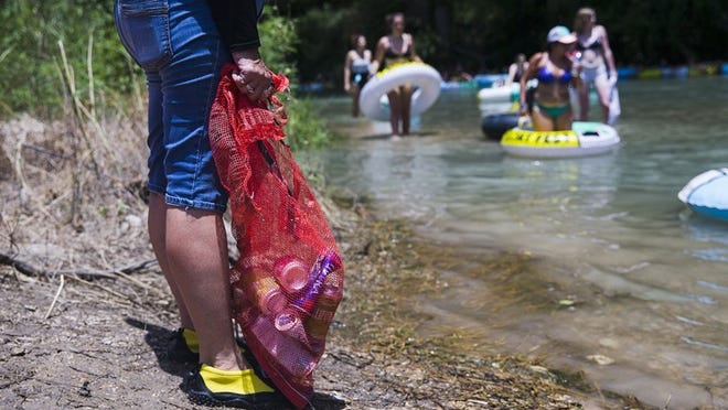 Volunteers gather trash and recyclables during Float Fest 2018 on Sunday, July 22, 2018, in San Marcos, TX. Float Fest is an annual music festival where attendants enjoy live music, camping and floating on the river. AMANDA VOISARD/AMERICAN-STATESMAN