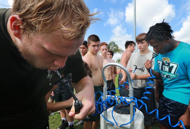 Flagler Palm Coast football players take a water break during conditioning drills on Wednesday. [Jim Tiller/Gatehouse Media Services]