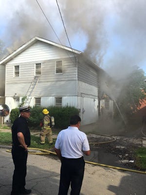 Erie firefighters were working to contain a fire that broke out in an apartment house on the city's west side on July 27. [TIM HAHN/ERIE TIMES-NEWS]