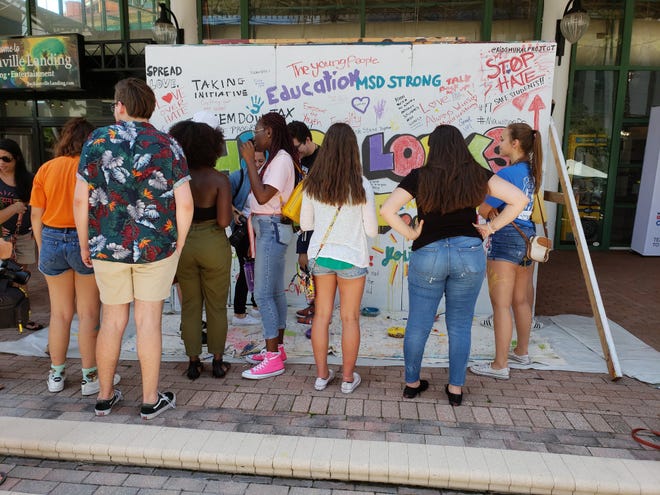 Jacksonville students joined survivors of the Valentine's Day massacre at South Florida's Marjory Stoneman Douglas High School at a "Road to Change" block party for teens at The Jacksonville Landing. One of the activities was to fill this "Change Looks Like..." banner with hopeful sayings. [Dan Scanlan/Florida Times-Union]