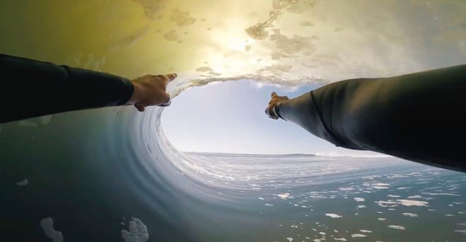 In this image made from video provided by Chris Rogers, surfer Koa Smith points through the barrel of the wave. [Chris Rogers/via The Associated Press]