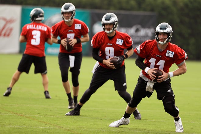 Eagles quarterbacks from right, Carson Wentz, Nick Foles, Nate Sudfeld and Joe Callahan run a drill during training camp Friday in Philadelphia. Wentz watched all the team’s full-scrimmage sessions from the sideline on Sunday. [MATT ROURKE / THE ASSOCIATED PRESS]