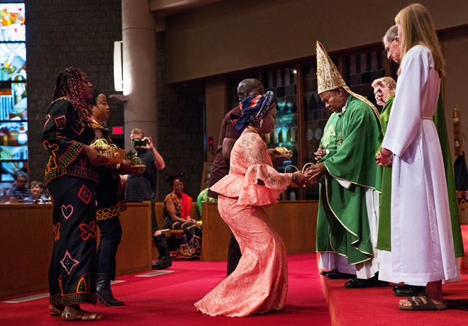 Lucy Tankoua presents a basket of strawberries to Archbishop Cornelius Fontem Esua from the Archdiocese of Bamenda, Cameroon, during the offertory at St. Agnes Catholic Church Sunday, July 29, 2018. The special service included music by the African Ensemble of Central Illinois, authentic African art and a meal of African food afterwards. [Ted Schurter/The State Journal-Register]