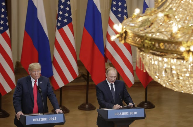 U.S. President Donald Trump, left, listens to Russian President Vladimir Putin during a press conference after their meeting at the Presidential Palace in Helsinki, Finland, Monday, July 16, 2018. [ MARKUS SCHREIBER/AP PHOTO ]