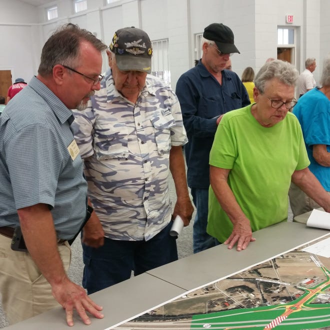 Phillip Craver (left), assistant district engineer with the North Carolina Department of Transportation, discusses the project to widen Hickory Tree Road with property owners Bob and Jackie Steelman during a public meeting on Monday. [Sharon Myers/The Dispatch]