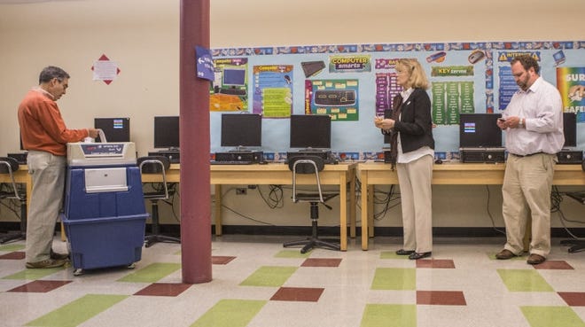 An election supervisor reviews results at the Thompson Middle School polling site in Newport after polls closed for the Sept. 9, 2014, primary. [ PHOTO BY JACQUELINE MARQUE]