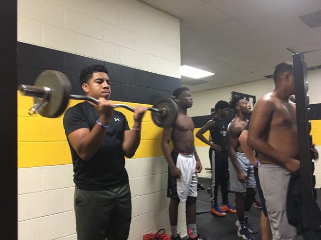 Pamlico County football players do curls in the weight room Monday evening on the NCHSAA first day of prep football practice. [JORDAN HONEYCUTT / SUN JOURNAL STAFF]