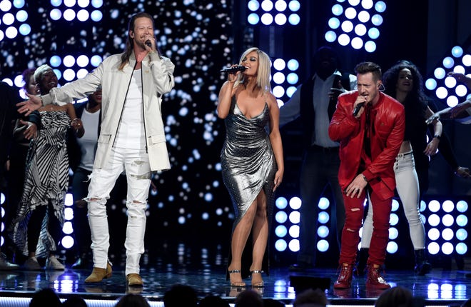 FILE - In this April 15, 2018 file photo, Tyler Hubbard, right, and Ormond Beach native Brian Kelley, left, of Florida Georgia Line, and Bebe Rexha, center, perform "Meant to Be" at the 53rd annual Academy of Country Music Awards in Las Vegas. The crossover hit “Meant To Be” has broken a new record on the Billboard Hot Country chart, remaining in the No. 1 spot for 35 weeks. (Photo by Chris Pizzello/Invision/AP, File)