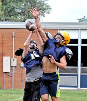 Alex Becker (right), who intercepted seven passes a year ago for Hillsdale, bats away a pass intended for receiver Braxton Slagle in practice Wednesday. Becker will also take over at quarterback for the Falcons and new head coach Trevor Cline this year.