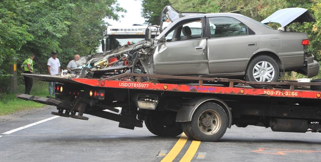 A tow truck removes the heavily damaged car from the scene of the crash early Saturday morning on Route 28 just west of Route 130 in which two people died and another person was critically injured and found to be brain-dead on arrival at a hospital. Mashpee police have opened an internal investigation into the pursuit that preceeded the crash, which crossed into the town of Barnstable. [Cape Cod Times, file / Steve Heaslip]