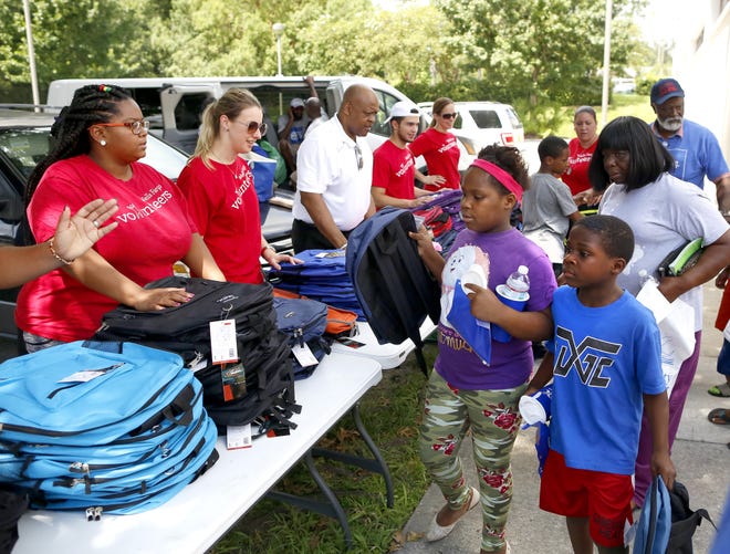 Kids receive backpacks during the 19th annual Stop the Violence Back to School Rally held at the Santa Fe College gym Saturday. [Photos by Brad McClenny/Special to the Guardian ]