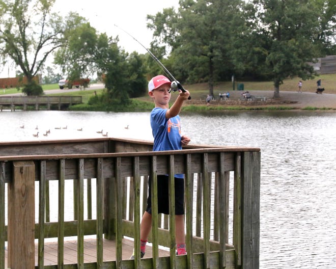 Jack Taylor takes advantage of the cloud cover Tuesday, July 31, 2018, to try his luck fishing at Wells Lake in Chaffee Crossing. Jack is the 8-year-old son of Amanda and Brent Taylor of Alma. [JAMIE MITCHELL/TIMES RECORD]