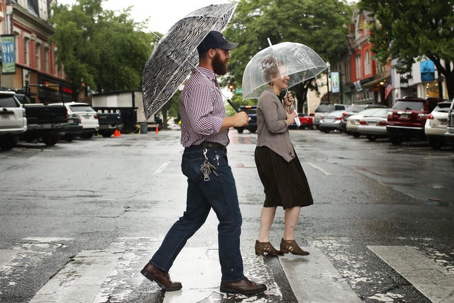 People cross Clayton Street as rain pours down in Athens, Ga., Friday, June 1, 2018. Athens has seen record rainfall in the past few weeks. [Joshua L. Jones/Athens Banner-Herald]