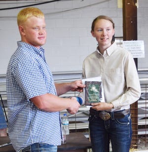 Lukas Aylesworth, left, Logan County Master Showmanship Contest Coordinator presents an award to Charlotte Toohill, right who was the overall winner of the Logan County Master Showmanship Contest. [Photo submitted]