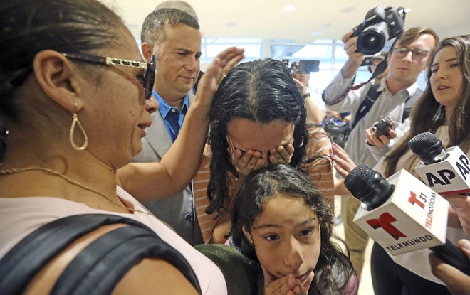 Alejandra Juarez,39, left, says goodbye to her children, Pamela and Estela, at the Orlando International Airport on Friday. [RED HUBER/ORLANDO SENTINEL via AP]