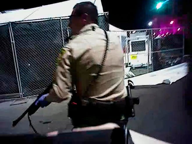 In this Sunday, Oct. 1, 2017, image taken from police body cam video released Wednesday, July 25, 2018, by the Las Vegas Metropolitan Police Department, an armed law enforcement official stands at the scene as authorities search for what they thought were multiple shooters inside and outside a Las Vegas Strip hotel, where a gunman firing from upper-floor windows killed 58 people and injured hundreds. (Las Vegas Metropolitan Police Department via AP)
