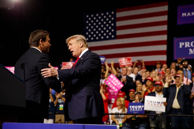 President Donald Trump shakes hands with Rep. Ron DeSantis during a campaign rally at Florida State Fairgrounds Expo Hall in Tampa last week. [THE ASSOCIATED PRESS]