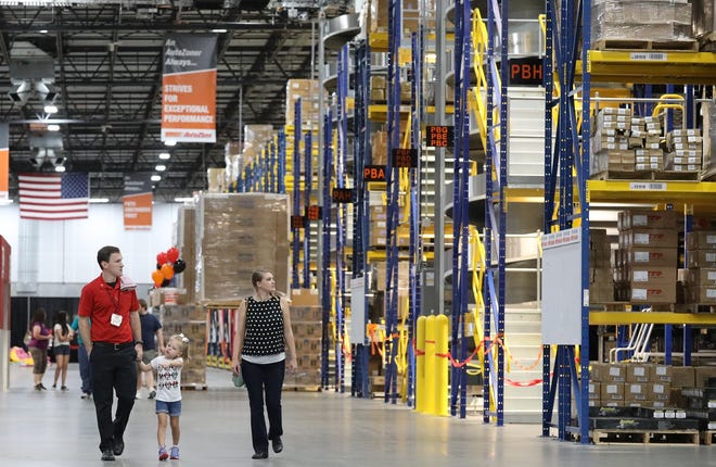 AutoZone employee Austin Canen, left, shows the new 460,000-square-foot distribution center in Ocala to his family on July 21. Jobs like this have brought the unemployment rate down across the state since the Great Recession, but often at low wages and in industries like distribution where workers may find their jobs threatened by emerging technology. [Doug Engle/Staff photographer]