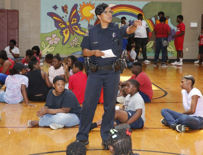 Tuscaloosa Police officer Lillie Leatherwood gives directions as the Police Athletic League prepares to distribute 360 backpacks filled with school supplies Friday August 3, 2018. [Staff Photo/Gary Cosby Jr.]