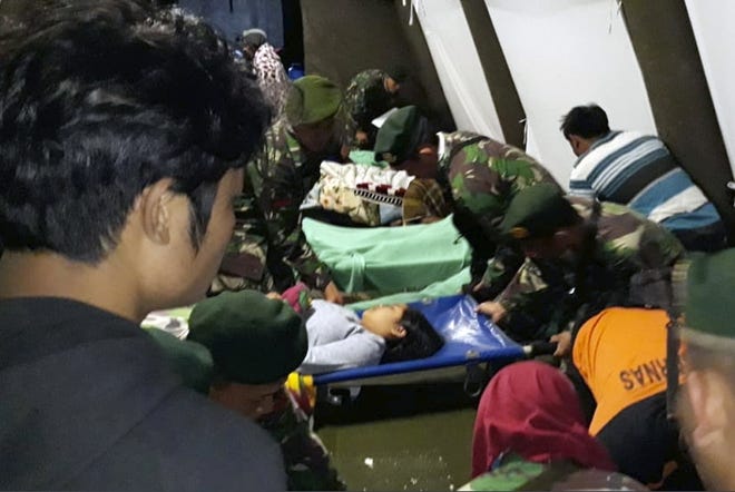 Indonesian soldiers tend to a woman injured in the earthquake at a makeshift hospital in Lombok, Indonesia, Sunday, Aug. 5, 2018. A strong earthquake struck Indonesia's popular tourist island of Lombok on Sunday, triggering a tsunami warning, one week after another quake in the same area killed more than a dozen people. (AP Photo)