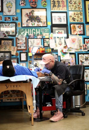 Billy Joe White, owner of Red Rose Tattoo in Zanesville, has made it his mission to help people move past hate. He offers free tattoos for people who want to cover up their existing hate tattoos. Photographed in his shop, Wednesday, August 2, 2018, tattooing a customer that is not a coverup. (Dispatch photo by Courtney Hergesheimer)