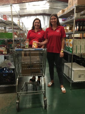 Amanda Fremin (left) and Brittany Gros volunteer at the Thibodaux Food Bank. [Submitted]
