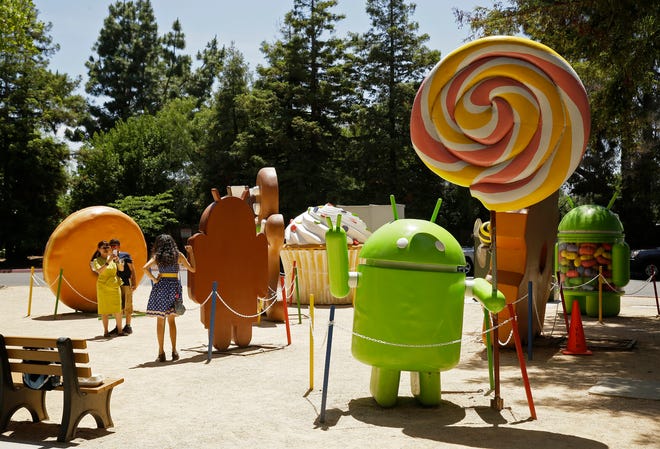 FILE - In this May 18, 2016, file photo, people pose by Android lawn statues at Google's headquarters in Mountain View, Calif. The next version of Google’s Android system will be called Pie. It will use artificial intelligence to adapt to how you use the device. (AP Photo/Eric Risberg, File)