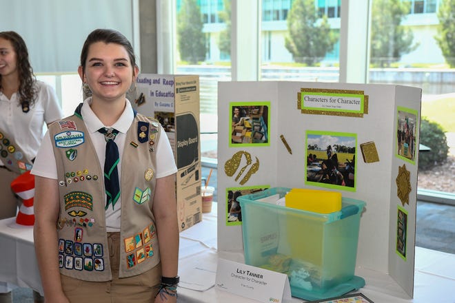 Lily Tanner stands next to her project presentation "Character for Character." [PHOTO PROVIDED BY GIRL SCOUTS OF WEST CENTRAL FLORIDA]
