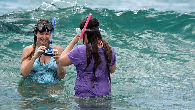 Sherry Hensel, left, with her daughter Heather Boldt, 13, as they work with the underwater camera to photograph fish while snorkeling at Red Reef Park in Boca Raton in 2008. (Palm Beach Post file photo)