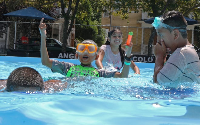 Oscar Alonzo, 11, center, and Gasper Suan, 10, right, play with friends in the pool Monday at the Zuccolo Recreation Center in Providence. [The Providence Journal / Steve Szydlowski]