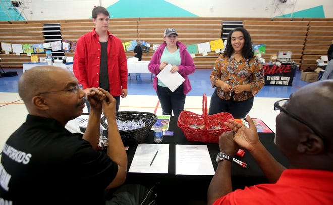 From left, David Harris, Megan Philbeck and Rachel Harris learn about ways to help Communities in Schools from Chip Beam and Alvin Hopper at Connect, Commit to Change. [Brittany Randolph/The Star]