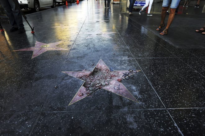 This July 25, 2018, file photo shows Donald Trump's vandalized star on the Hollywood Walk of Fame in Los Angeles. The West Hollywood City Council has unanimously approved a resolution seeking to remove President Donald Trump's star from the Hollywood Walk of Fame. The resolution urges the Hollywood Chamber of Commerce and Los Angeles to remove the star because of what it says is Trump's "disturbing treatment of women and other actions." (AP Photo/Reed Saxon, File)