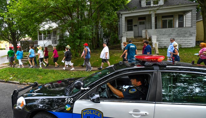 RON JOHNSON/JOURNAL STAR Members of Peoria Community Against Violence (PCAV), walk through East Bluff neighborhoods while escorted by a Peoria policeman during their "peace walk", part of the Night Out Against Crime event at the East Bluff Community Center on Tuesday.