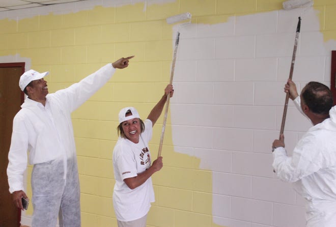 Members of the Petersburg Public Schools administration, including Superintendent Marcus J. Newsome, left, and Dr. Cindy Blount, center, join the School Board in painting Petersburg High School on Aug. 7, 2018. Groups from around the community have taken turns painting the school throughout the summer. [John Adam/progress-index.com]
