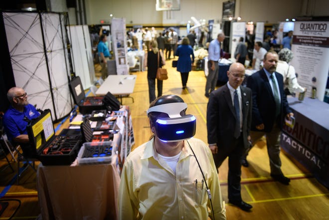 Mark Haselsberger tries out a VR headset at the U.S. Army Special Operations booth at the 17th Annual North Carolina Defense and Economic Development Trade Show on Tuesday at Fayetteville Technical Community College. [Andrew Craft/The Fayetteville Observer]